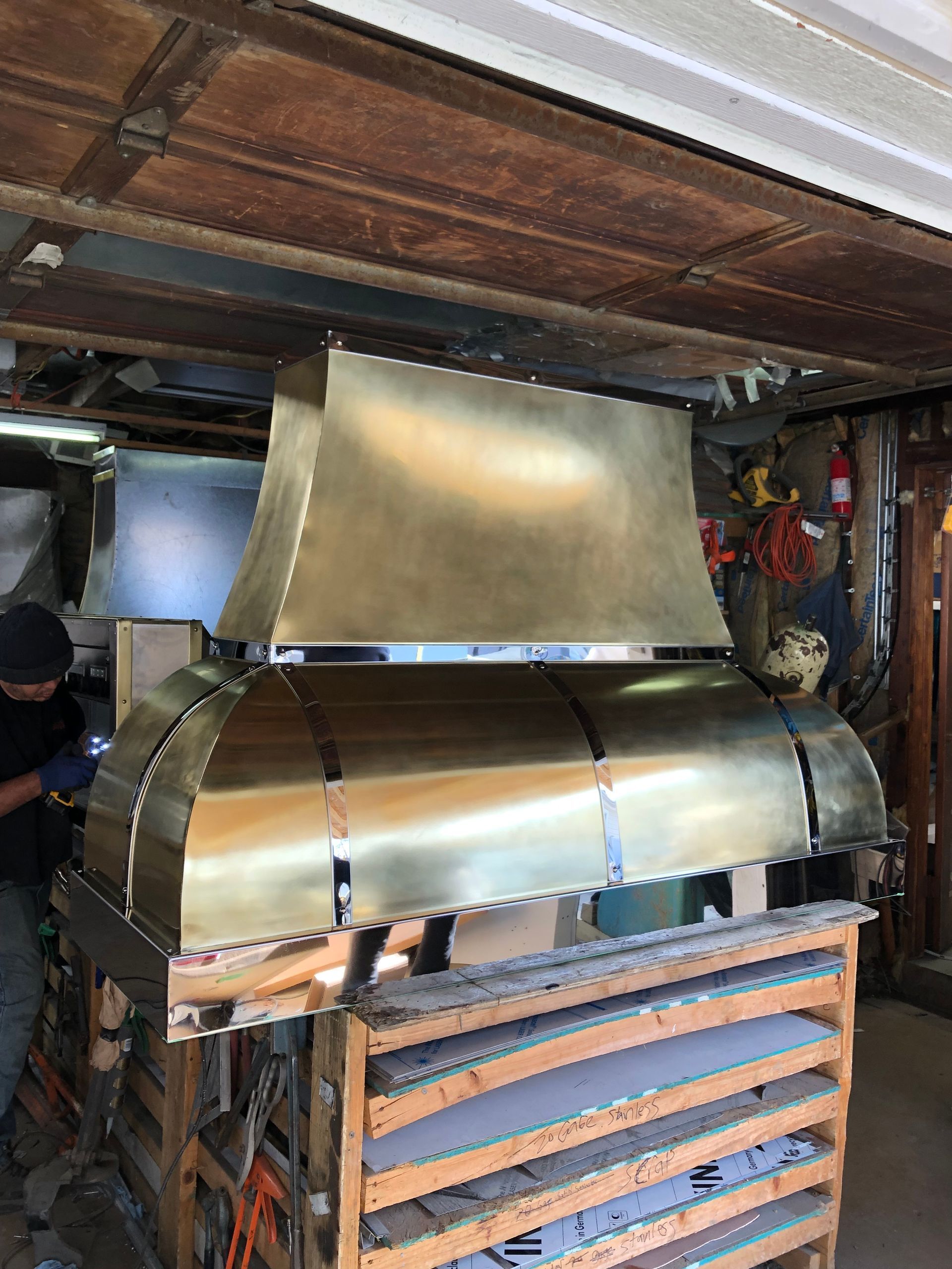 Metal ductwork and ventilation unit installed under a wooden ceiling in a basement.