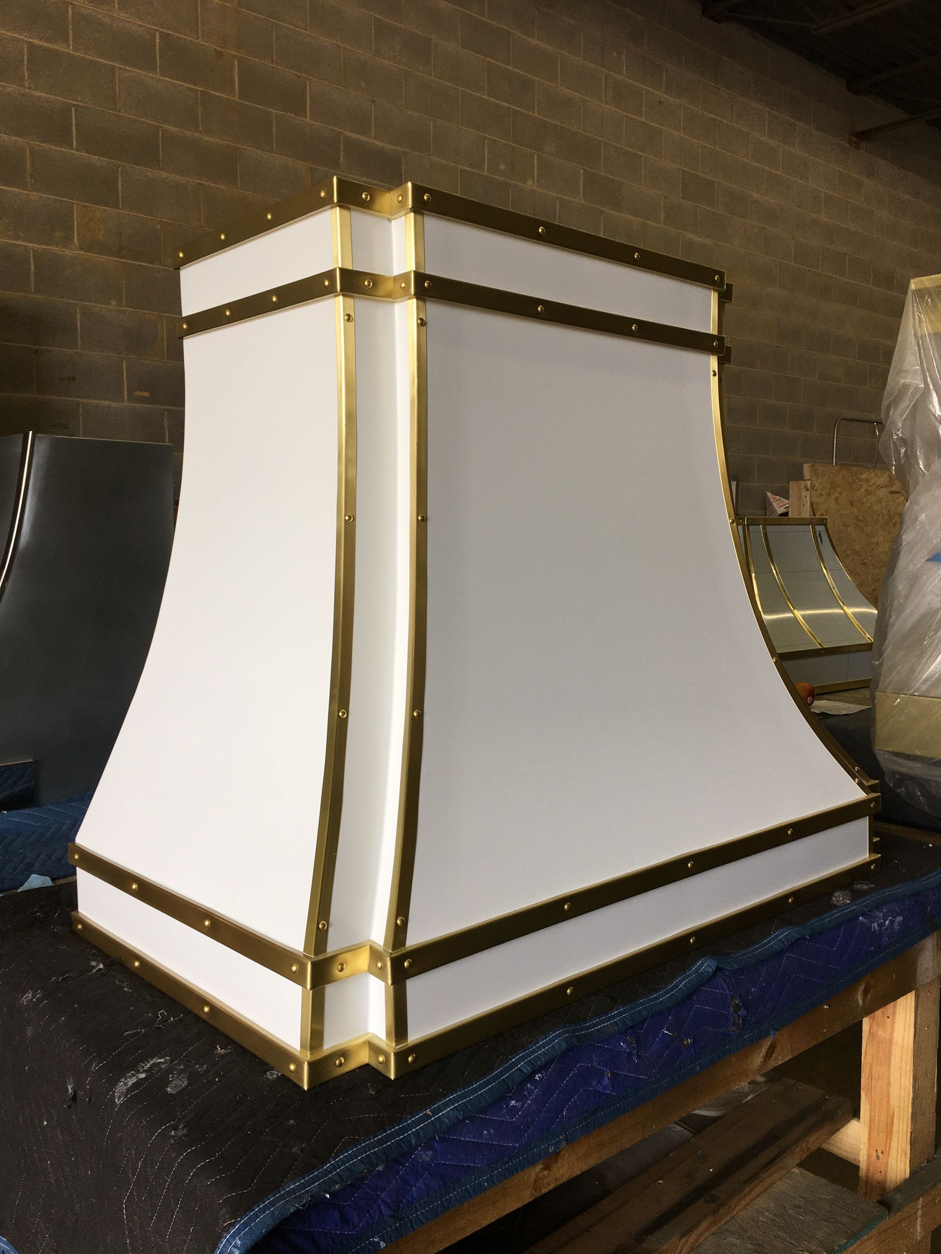 White and gold decorative lantern or lamp on a workbench against a brick wall
