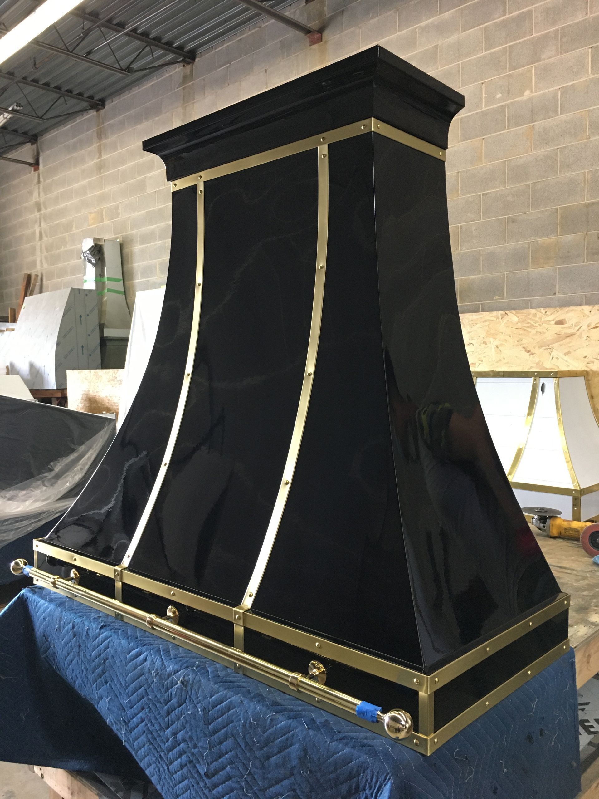 Black and gold ornate ceremonial cloth-covered structure in a warehouse or workshop