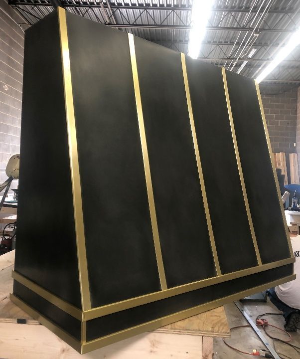 Large black-and-gold slanted panel structure in an industrial workshop