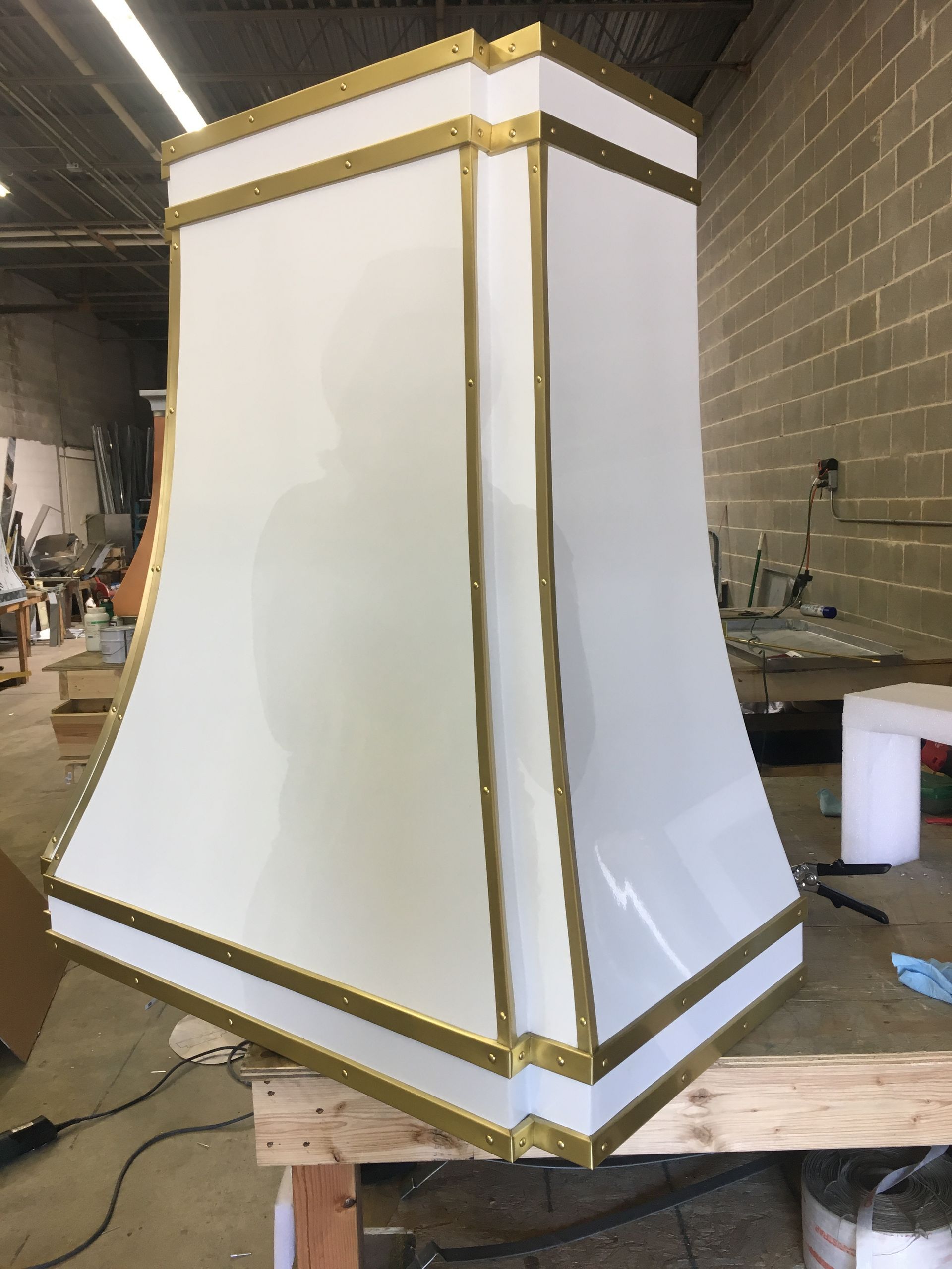 White and gold decorative column or pedestal in a workshop, mounted on a wooden stand