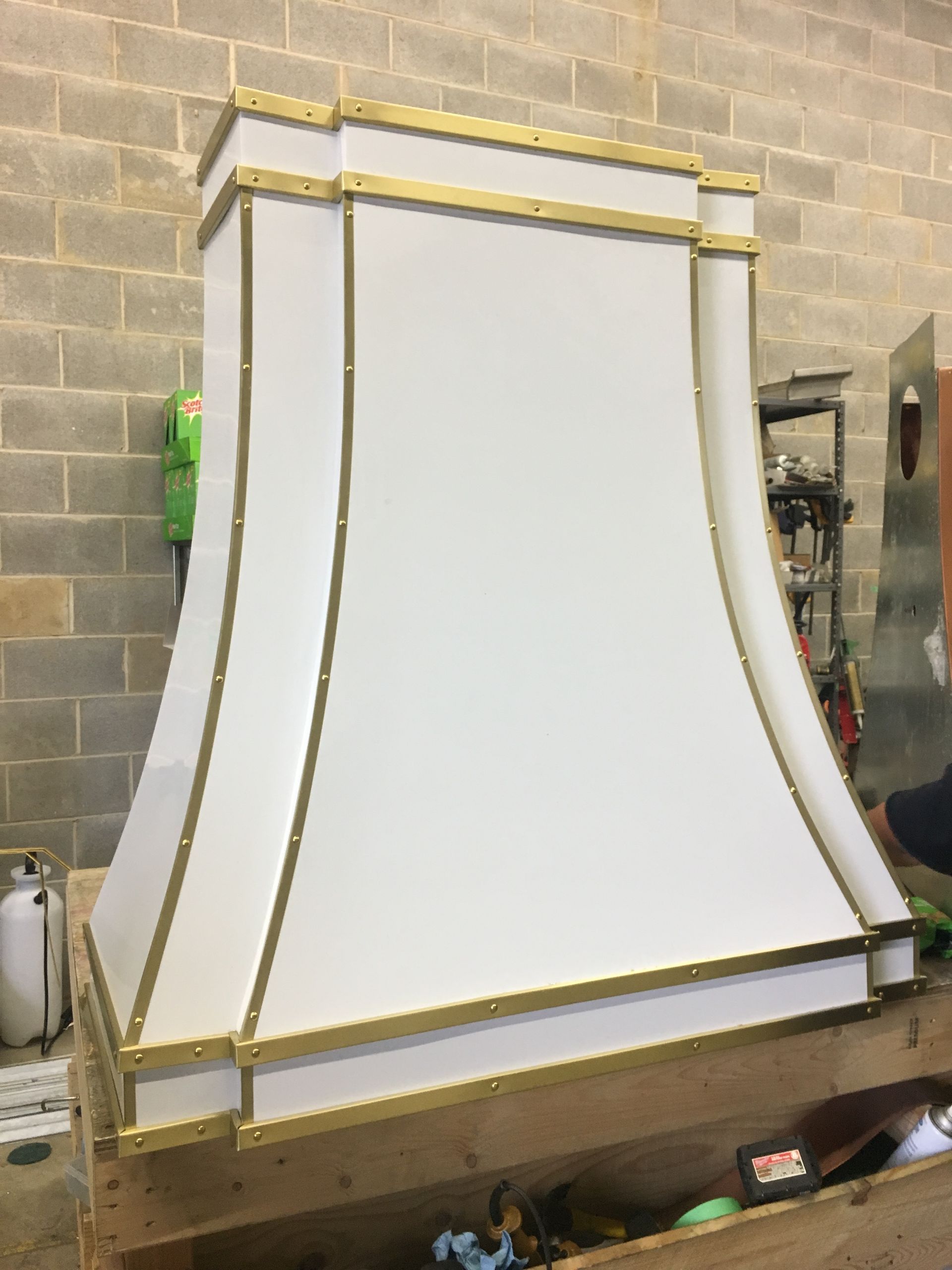 Large white and gold decorative panel or canopy leaning against a workshop wall
