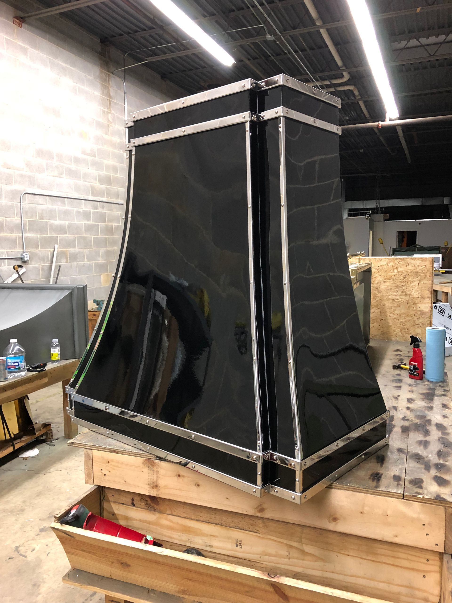 Black metal duct or cabinet on wooden pallets in a warehouse workshop