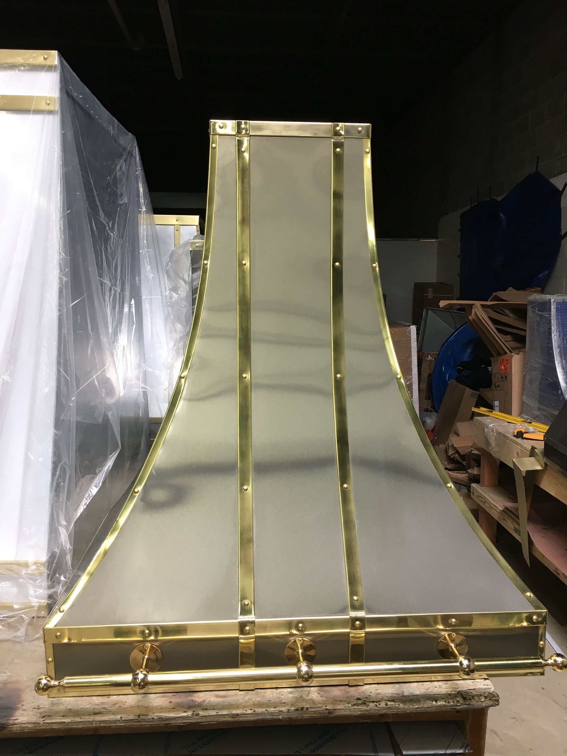 Gold-trimmed white slide in a warehouse/storage area, surrounded by wrapped equipment and pallets