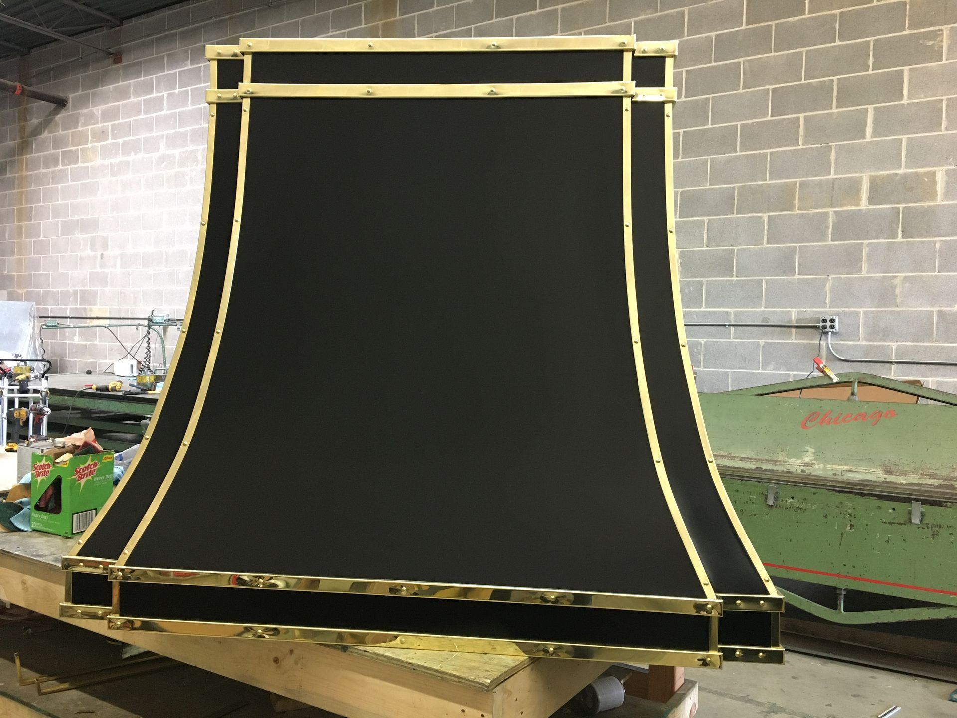 Black curved ramp structure with gold framing in an indoor workshop