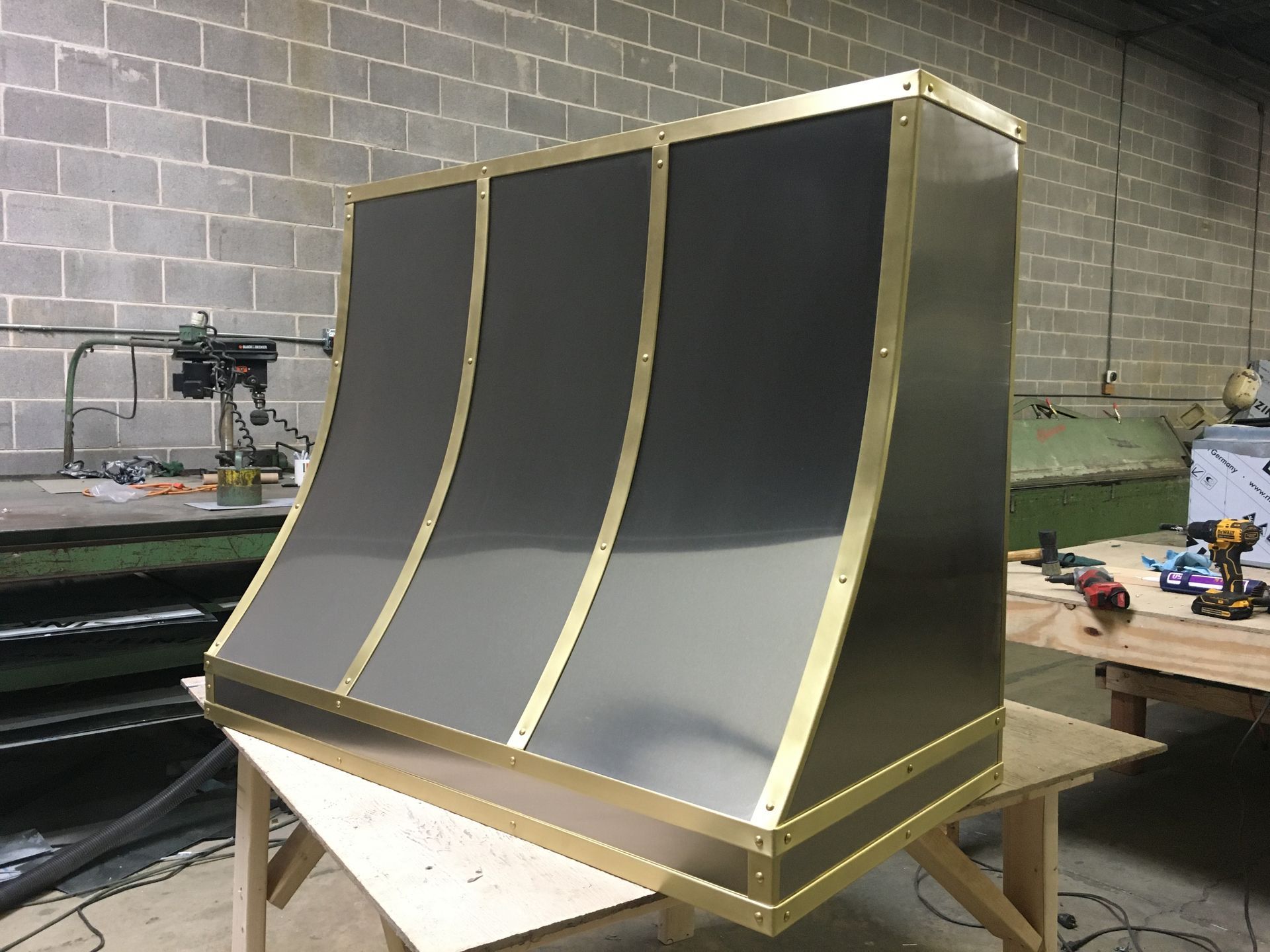 Curved black and gray industrial panel or mold on a workbench in a workshop