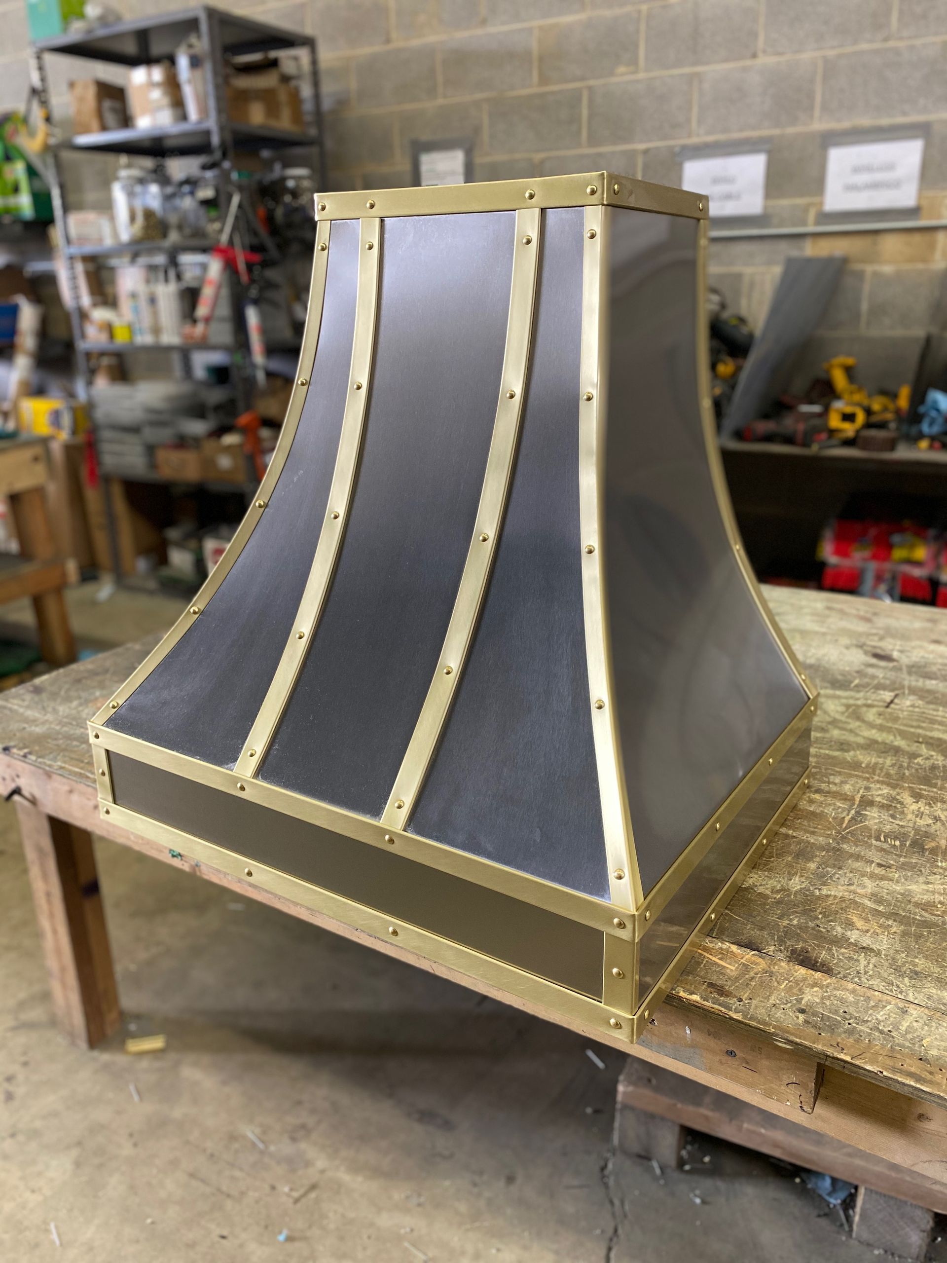 Gray tapered duct or hood with wooden framing on a workshop bench