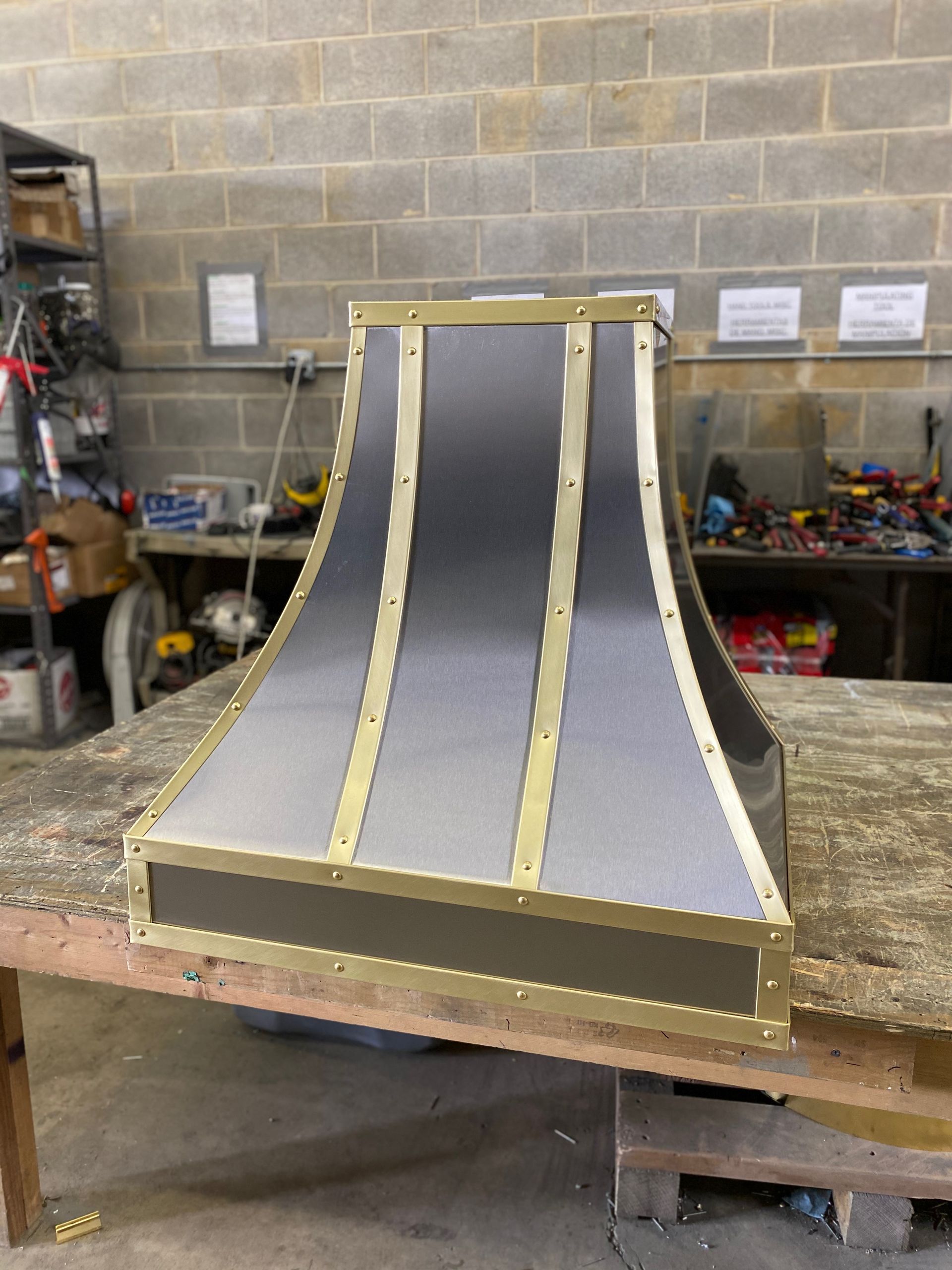 Scale model of a steep metal ramp with yellow trim on a workshop table