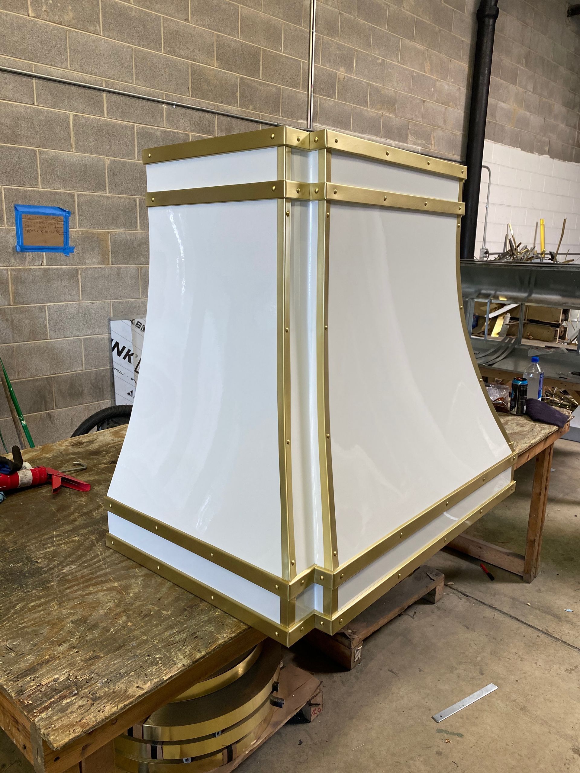 White boxed structure with gold trim on a workbench in a workshop