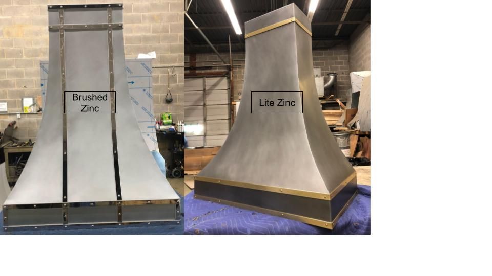 Two large industrial duct prototypes, one rectangular and one funnel-shaped, in a workshop.