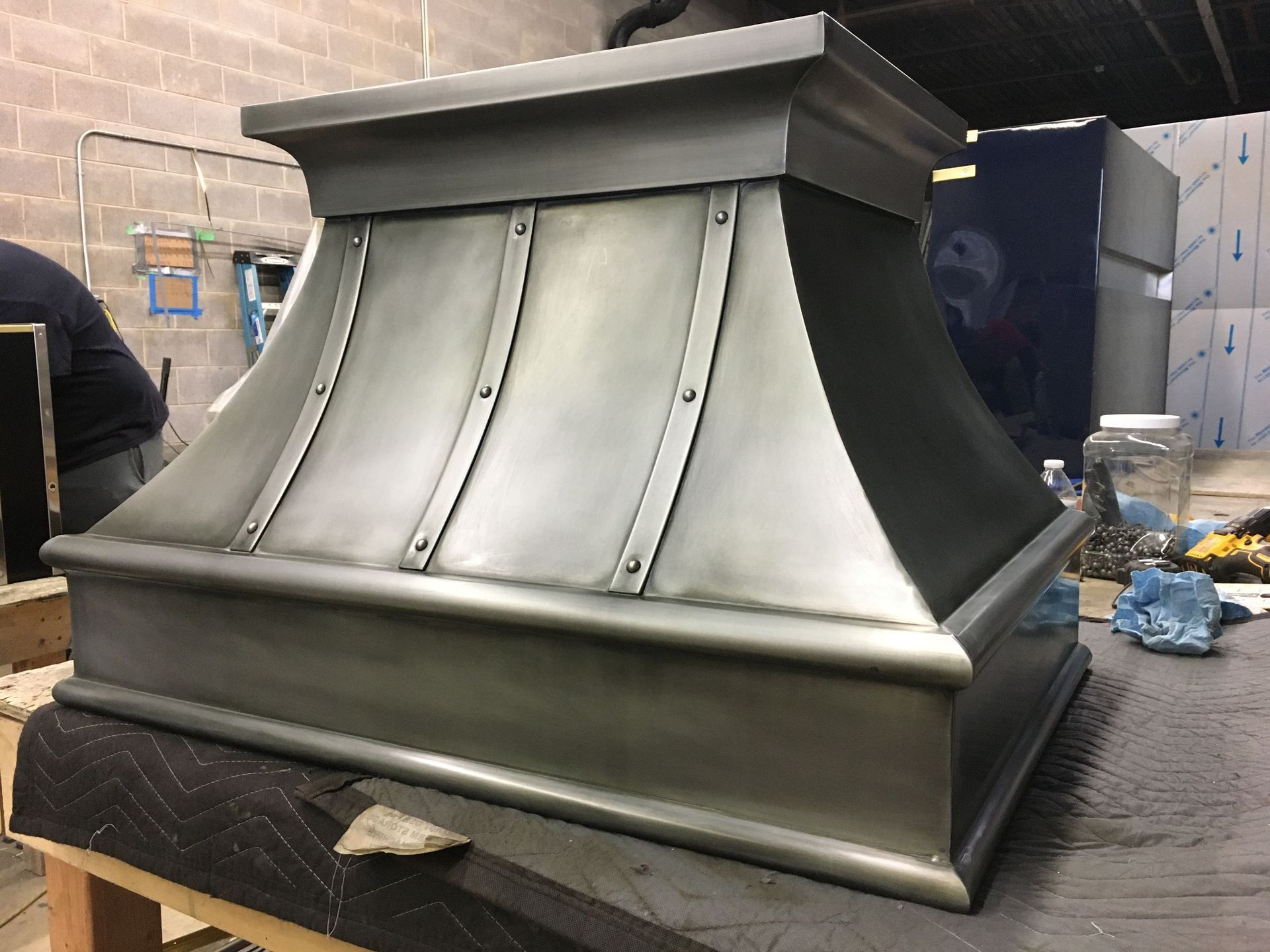 Silver decorative metal rooftop vent or chimney cap on a workshop table