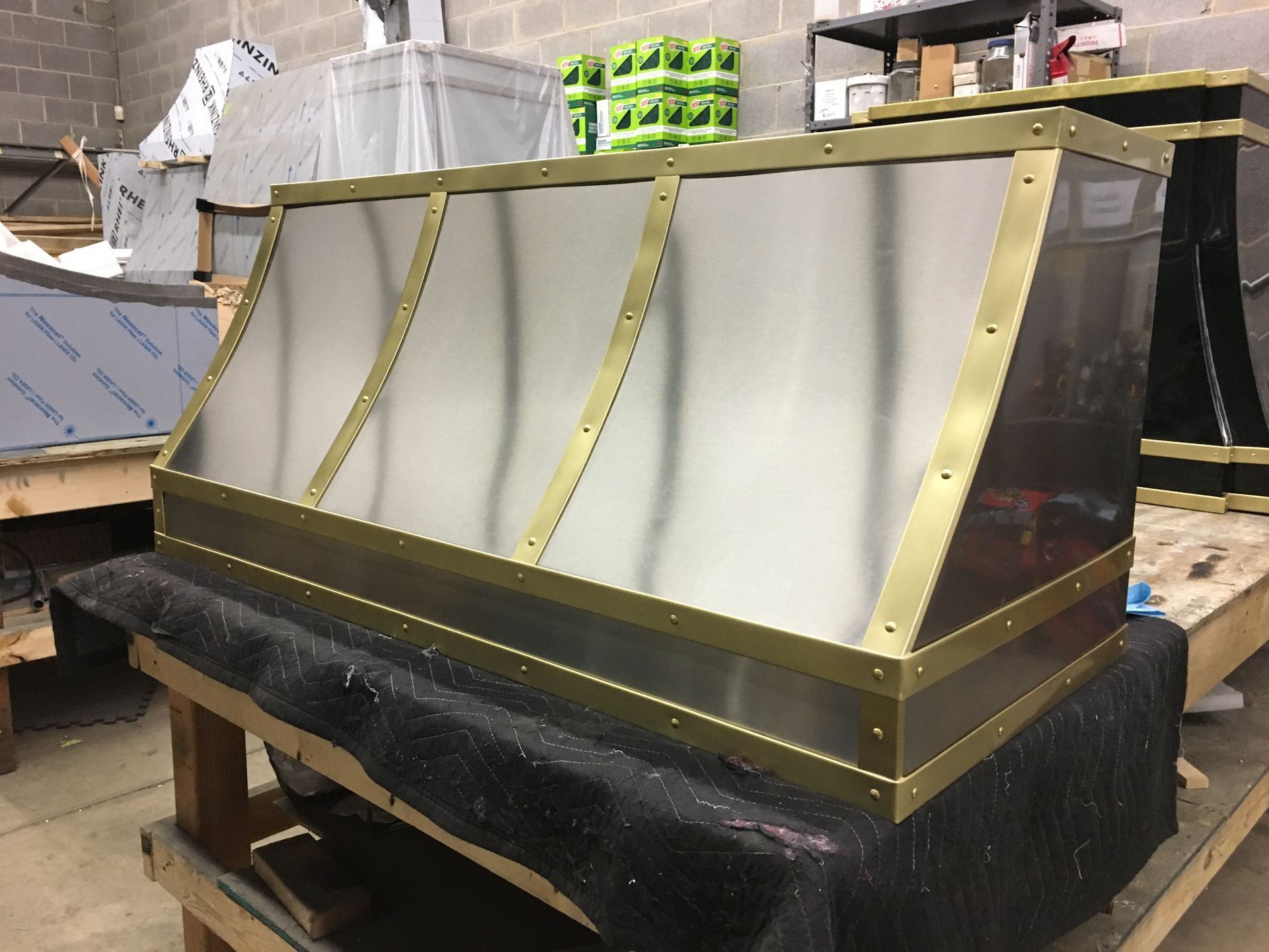 Industrial metal enclosure with gold framing on a wooden pallet in a warehouse