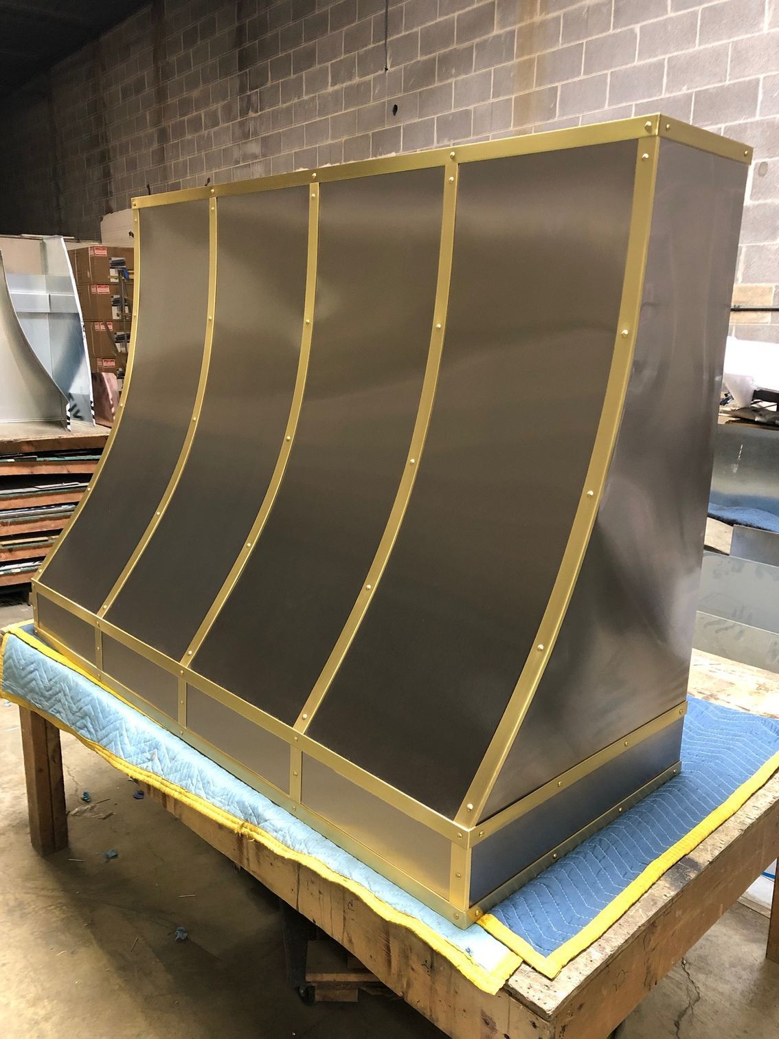 Large gold-and-gray curved display structure on a workbench in a workshop