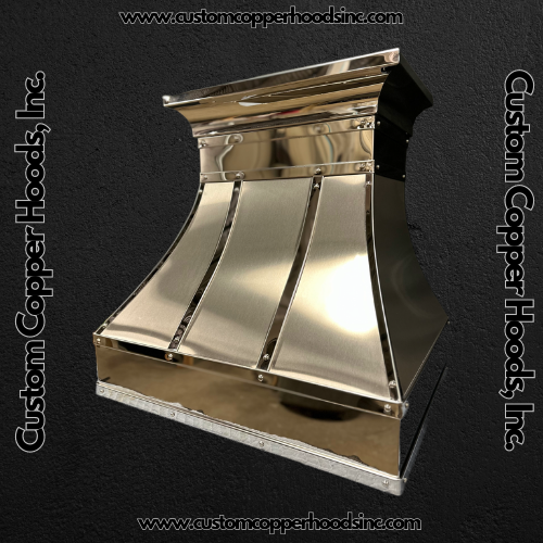 Shiny copper custom hood vent with curved panels on a dark background