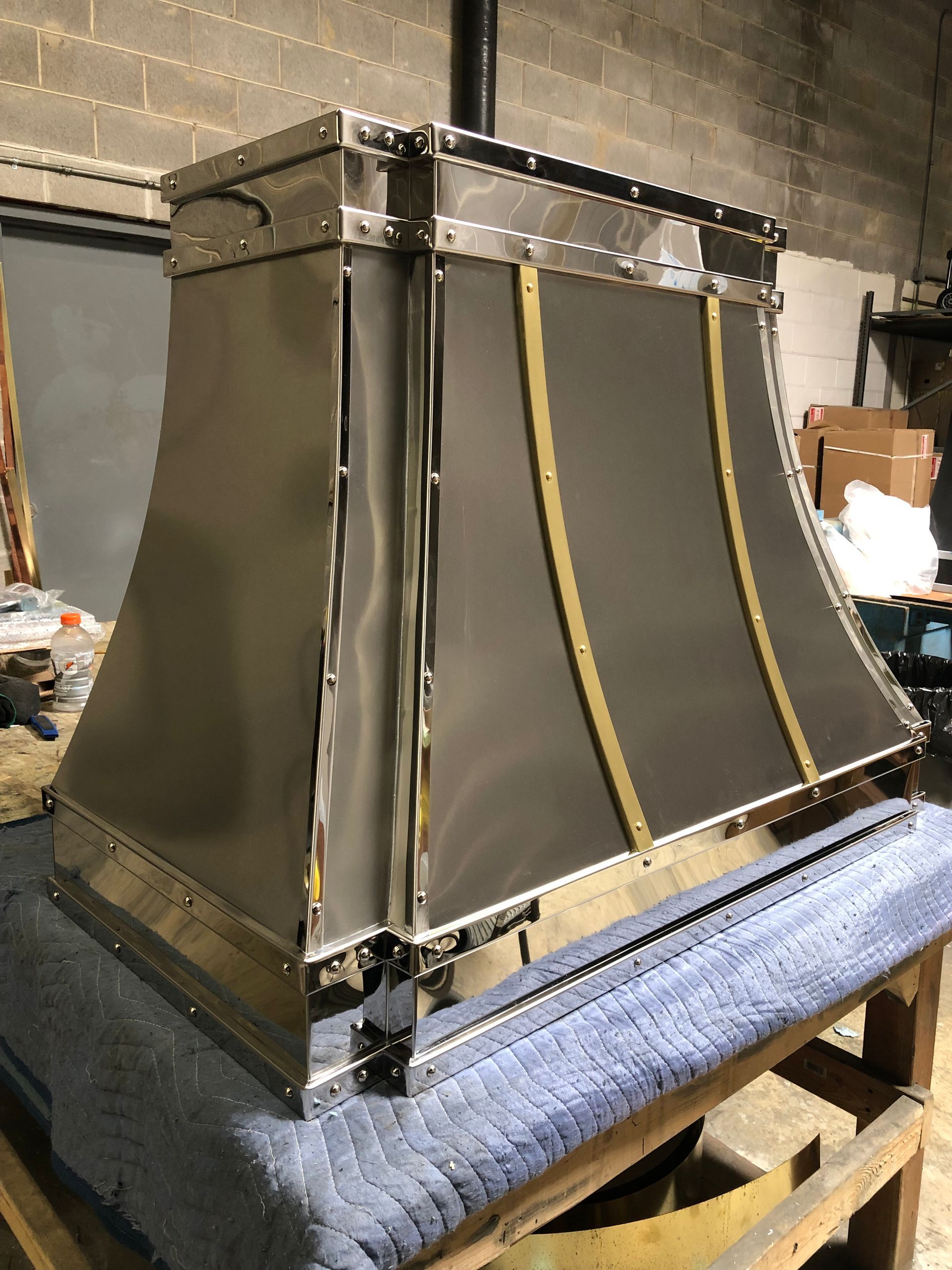Large black and gray industrial box with yellow straps on a blue padded workbench in a workshop