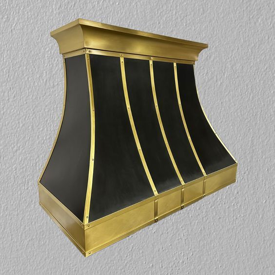 Gold-and-black wall-mounted fireplace hood with curved panels and brass trim