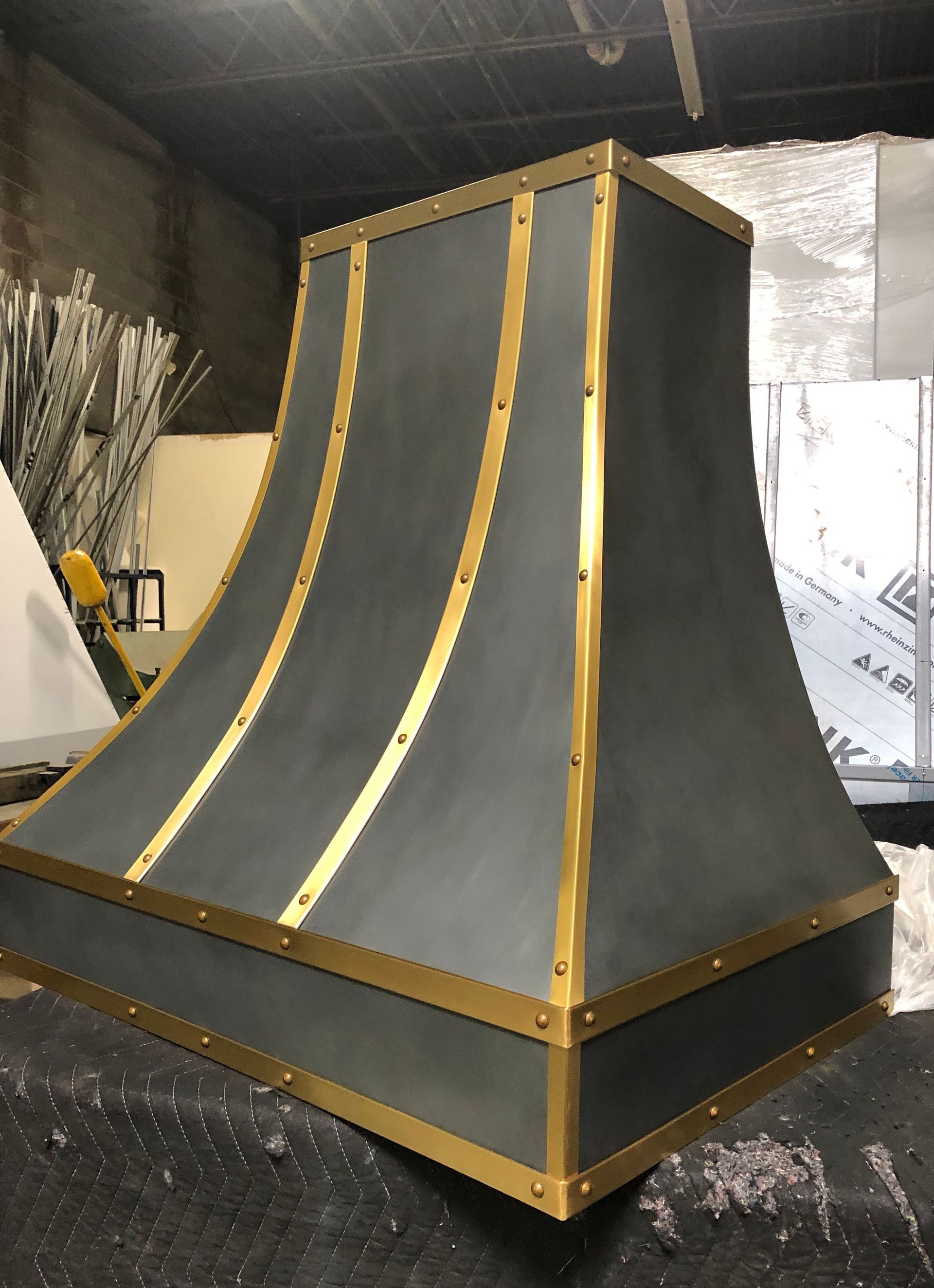 Black-and-gold custom ramp or stage structure in a workshop, with curved sides and wooden trim