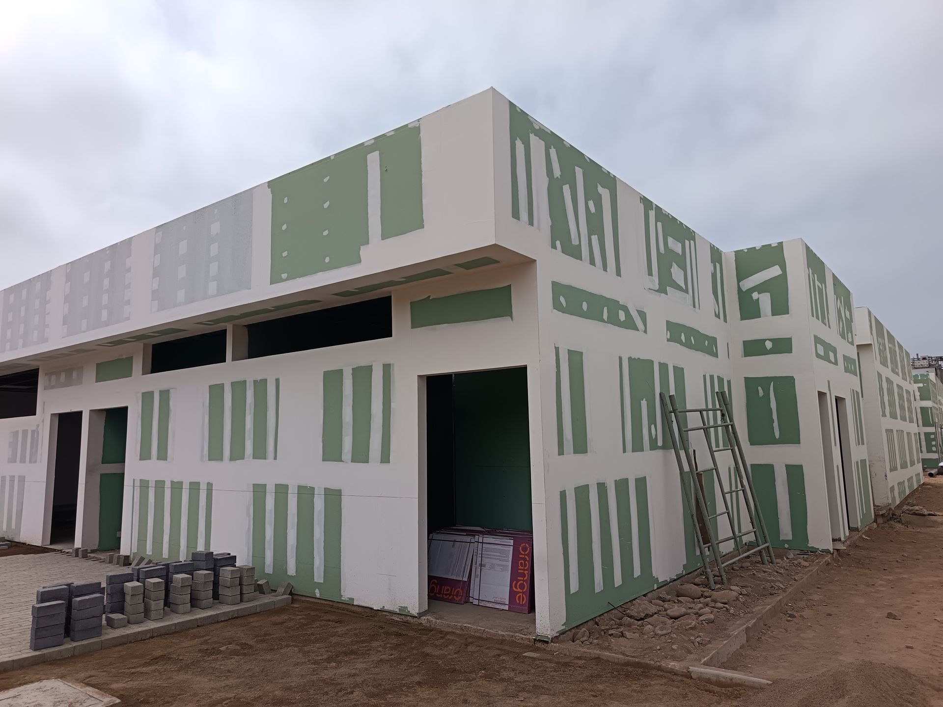 Plataforma elevadora amarilla estacionada dentro de un edificio con estructura de madera en construcción