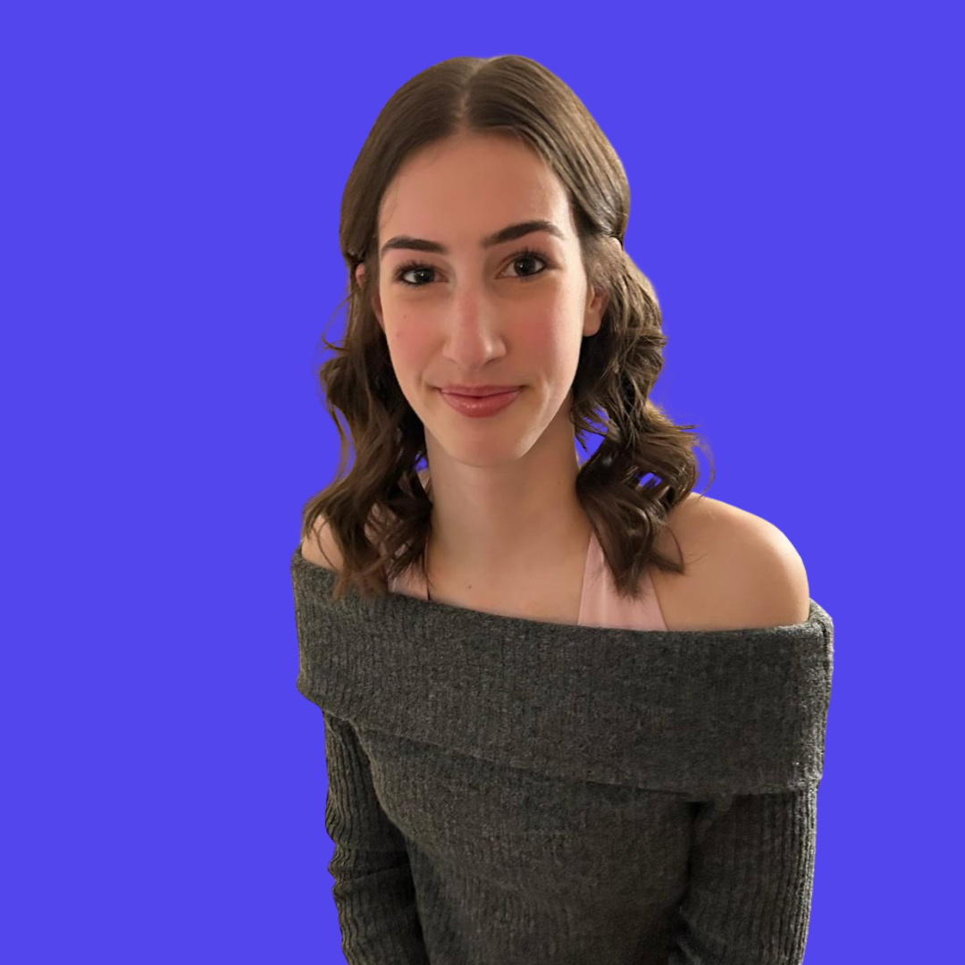 A woman wearing glasses is standing in front of a blue background.