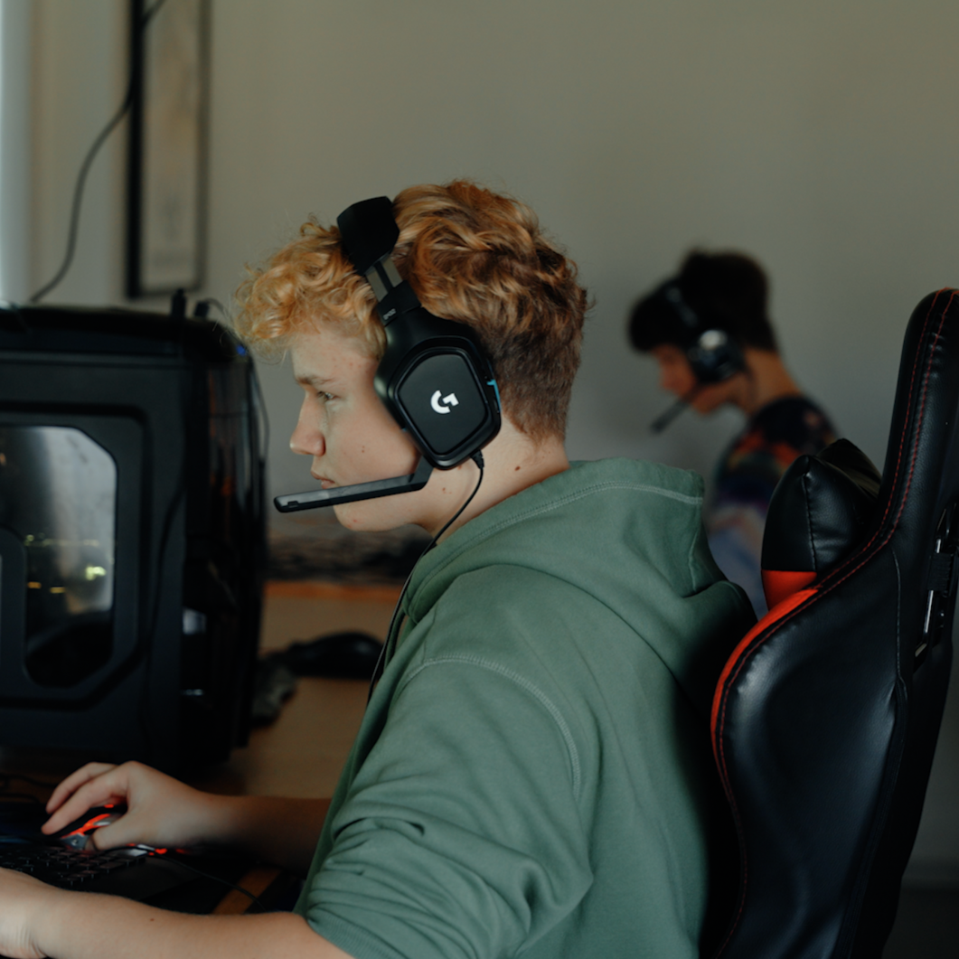 En mand iført hovedtelefoner spiller et videospil på Kongensgaard E-sport linje