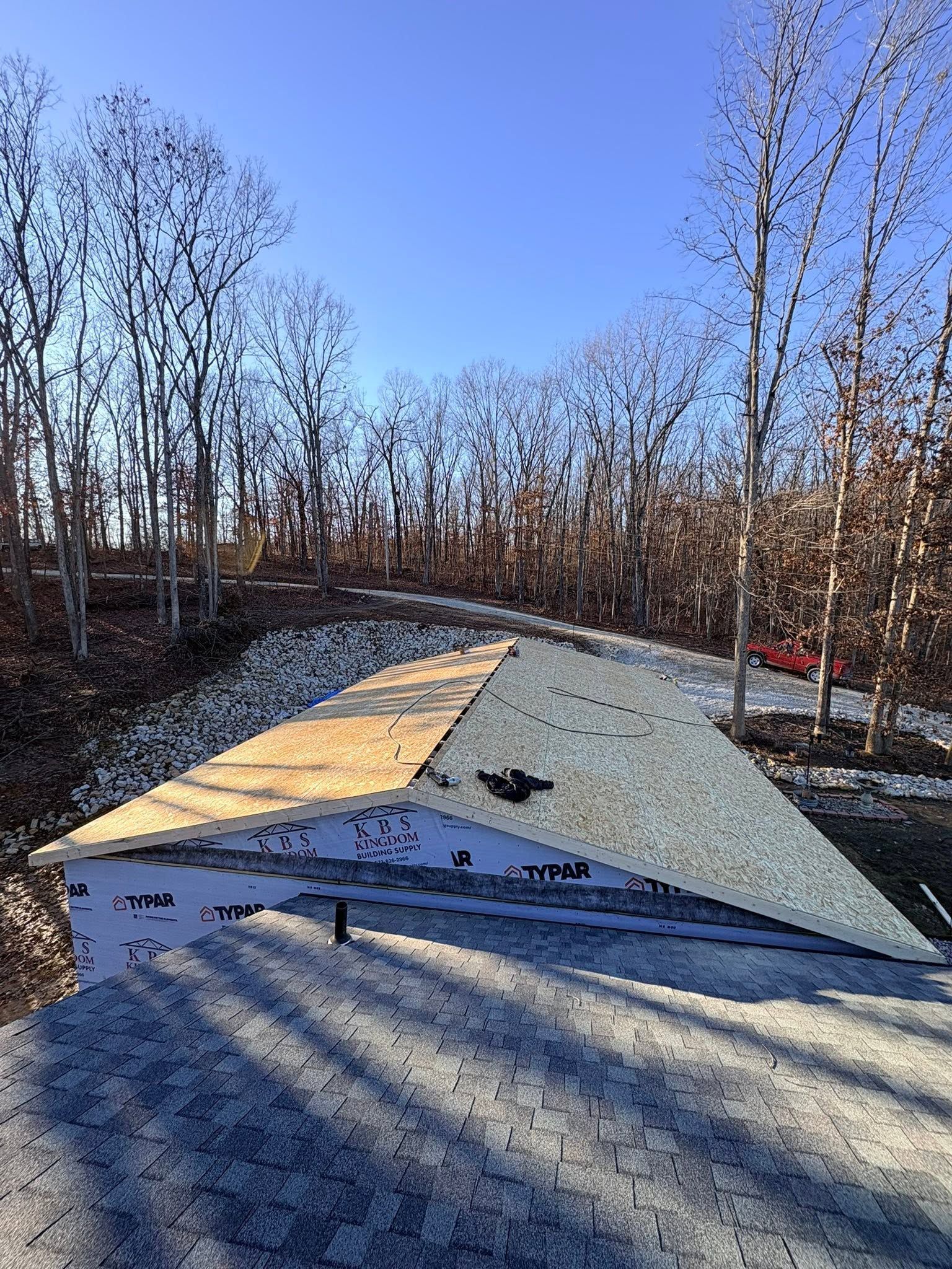 A colorful geometric outdoor ramp in a wooded park under a clear blue sky.