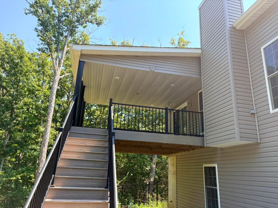 Exterior staircase leading to a covered second-floor deck on a beige house