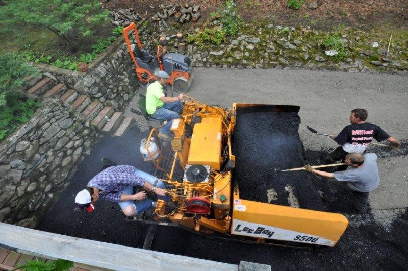 Man Shoveling Asphalt Pavement on Low Deck Asphalt Paver — Lunenburg, MA — Miller’s Paving, LLC