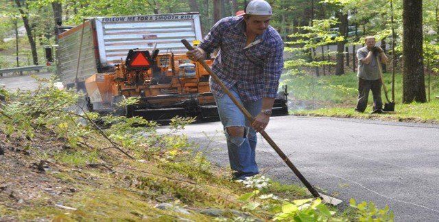 Man Holding Rake — Lunenburg, MA — Miller’s Paving, LLC