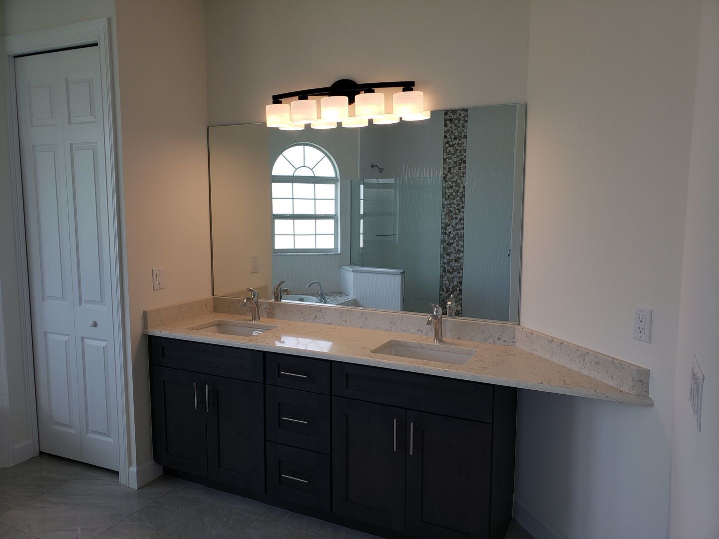 A bathroom with two sinks and a large mirror