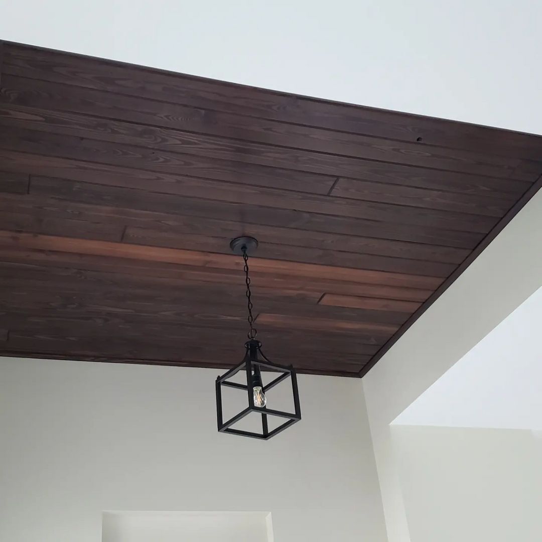 A wooden ceiling with a light hanging from it