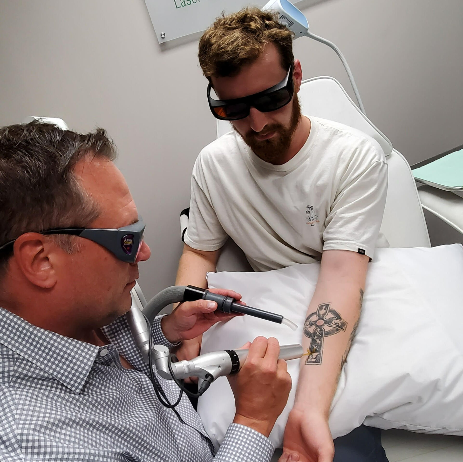 A man is getting a tattoo removed from his arm
