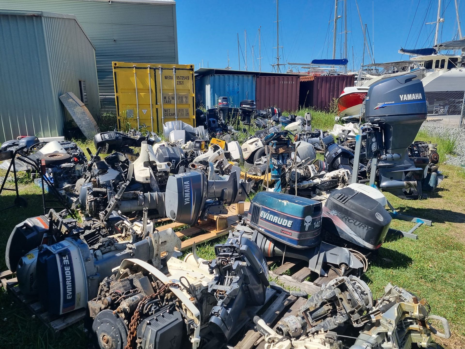 A boat engine is sitting on top of a pile of junk.