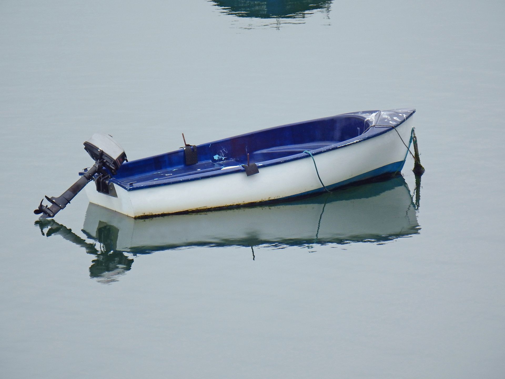 A boat engine is sitting on top of a pile of junk.