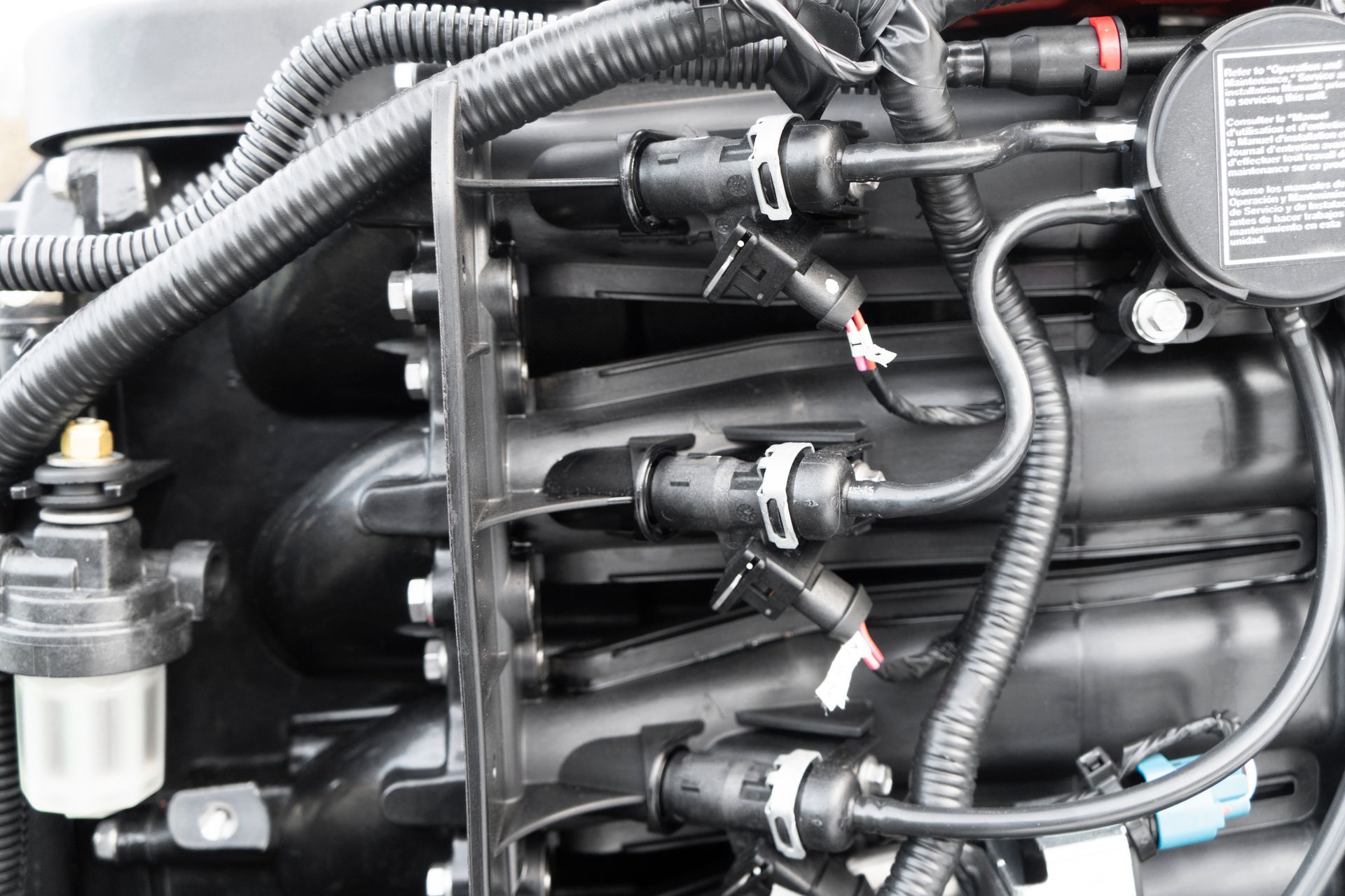 A close up of a boat engine with a lot of wires coming out of it.