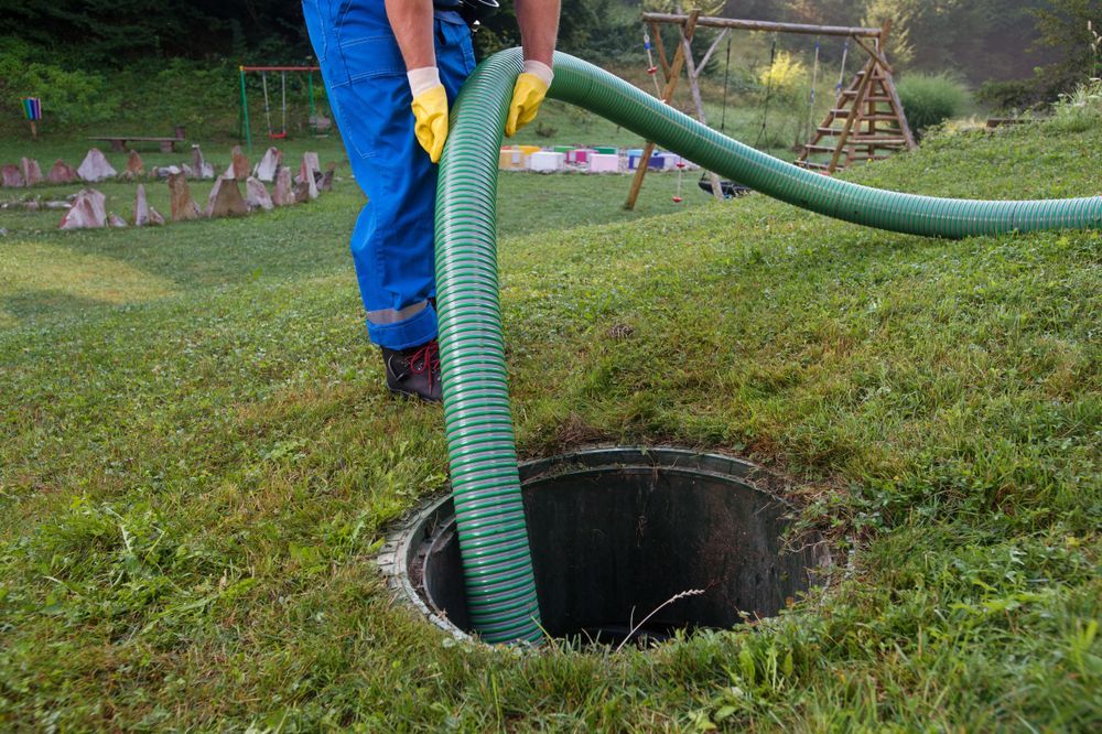 Worker in Blue Uniform and Yellow Gloves Handles a Hose — Evans Earthmoving Contractors In Mareeba, QLD