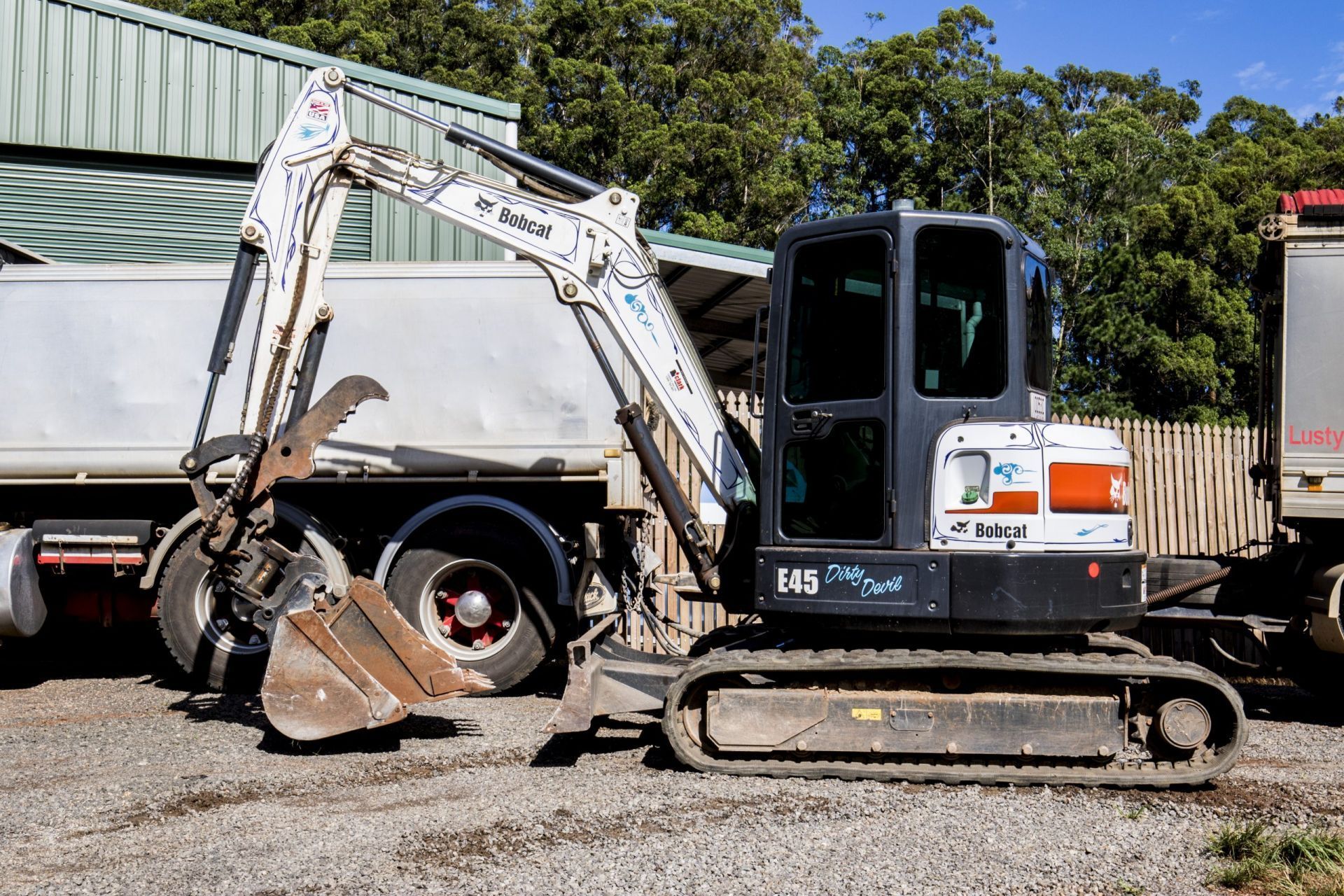 Bobcat E45 Compact Excavator Parked Next to Trucks — Evans Earthmoving Contractors In Malanda, QLD 