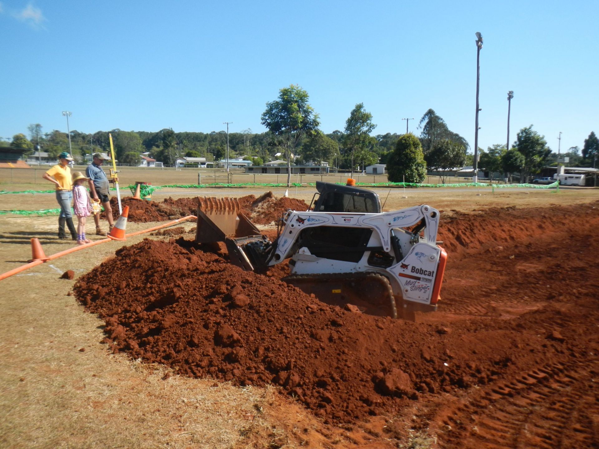 A Bobcat Skid-Steer Loader Excavates Red Dirt at An Outdoor Work Site — Evans Earthmoving Contractors In Malanda, QLD 