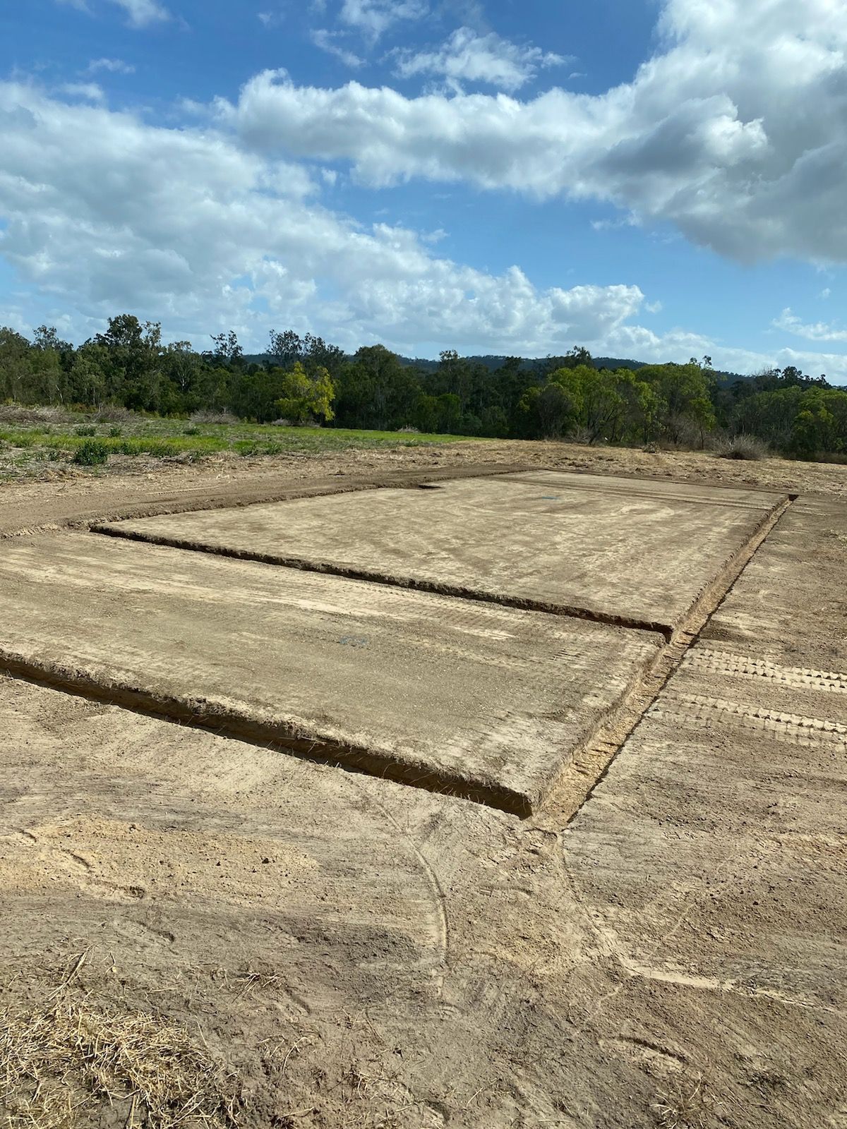 An Excavated Rectangular Foundation Outline in A Dirt Field Under a Cloudy Sky — Evans Earthmoving Contractors In Malanda, QLD 