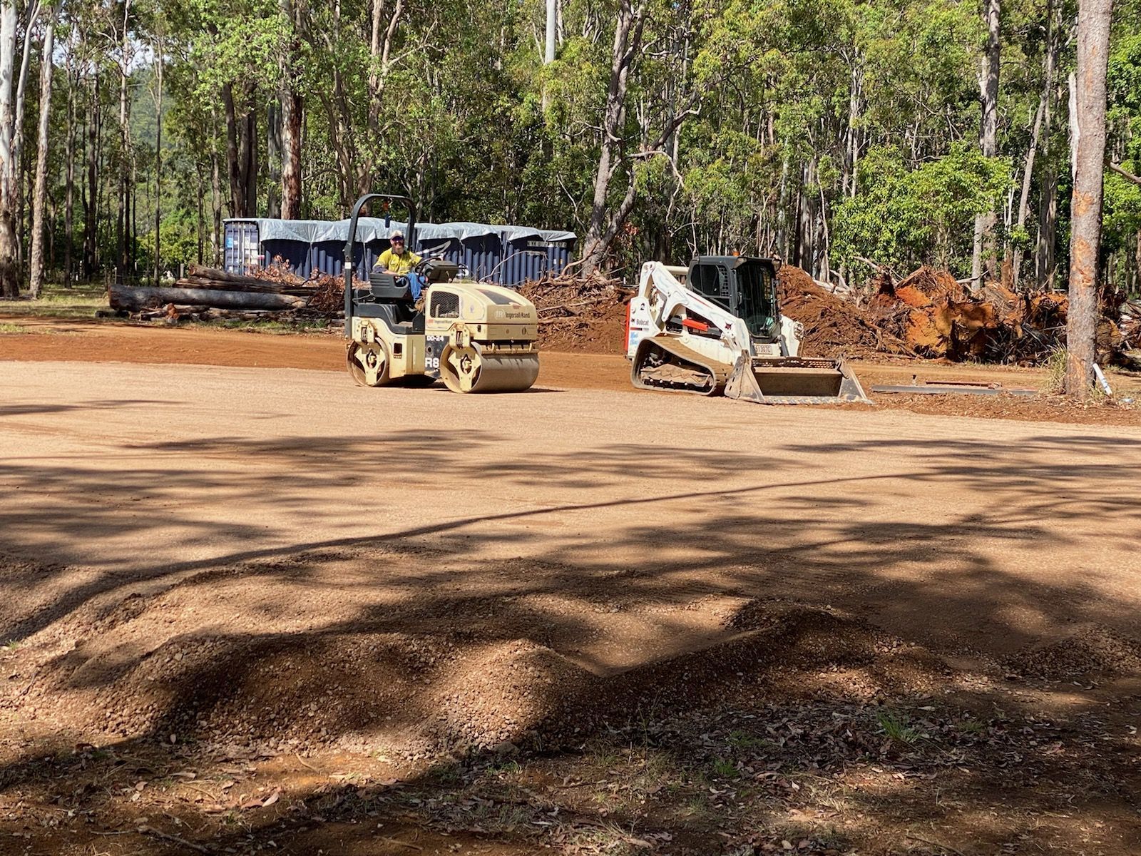 Roller and Bobcat Compacting Gravel — Evans Earthmoving Contractors In Malanda, QLD 