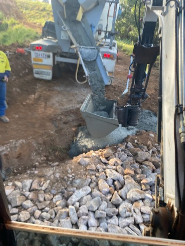 Construction Worker Shoveling Gravel From a Truck — Evans Earthmoving Contractors In Malanda, QLD