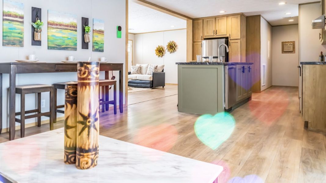 a manufactured home living room with a table and stools and a kitchen