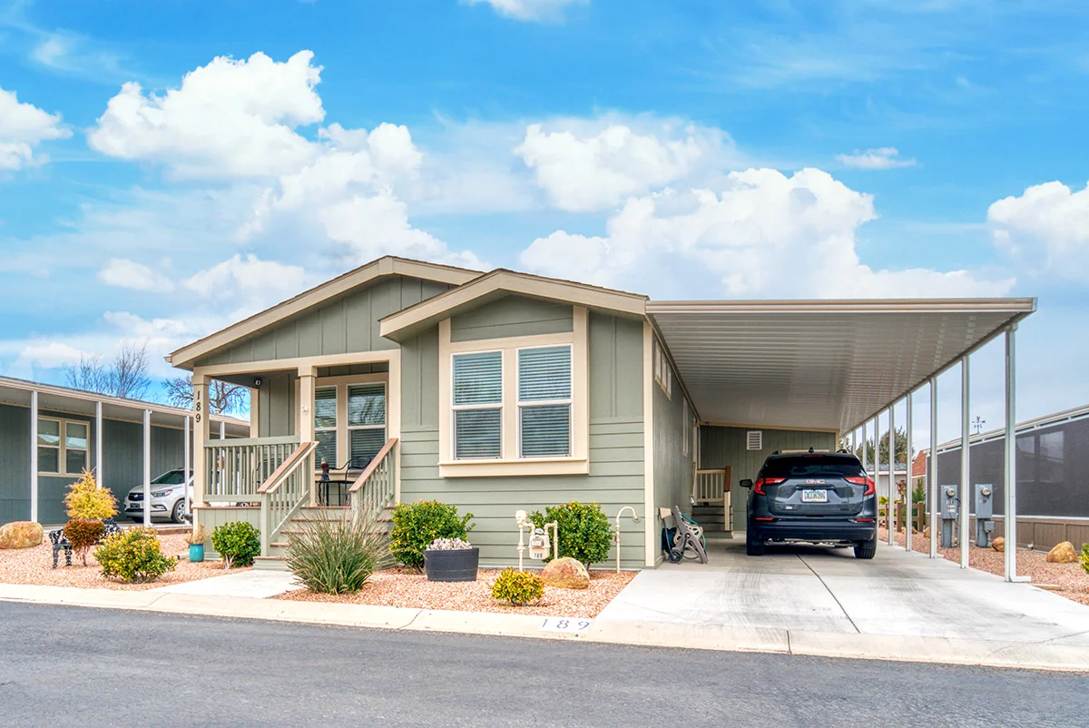 Older single-story home with a covered front porch, weathered exterior, and large grassy yard.