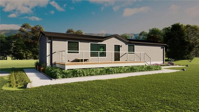 Single-story modern modular home with front porch deck, white siding, and landscaped lawn in a rural setting