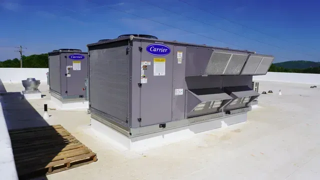 Roof-mounted HVAC units on a flat white rooftop under a clear blue sky