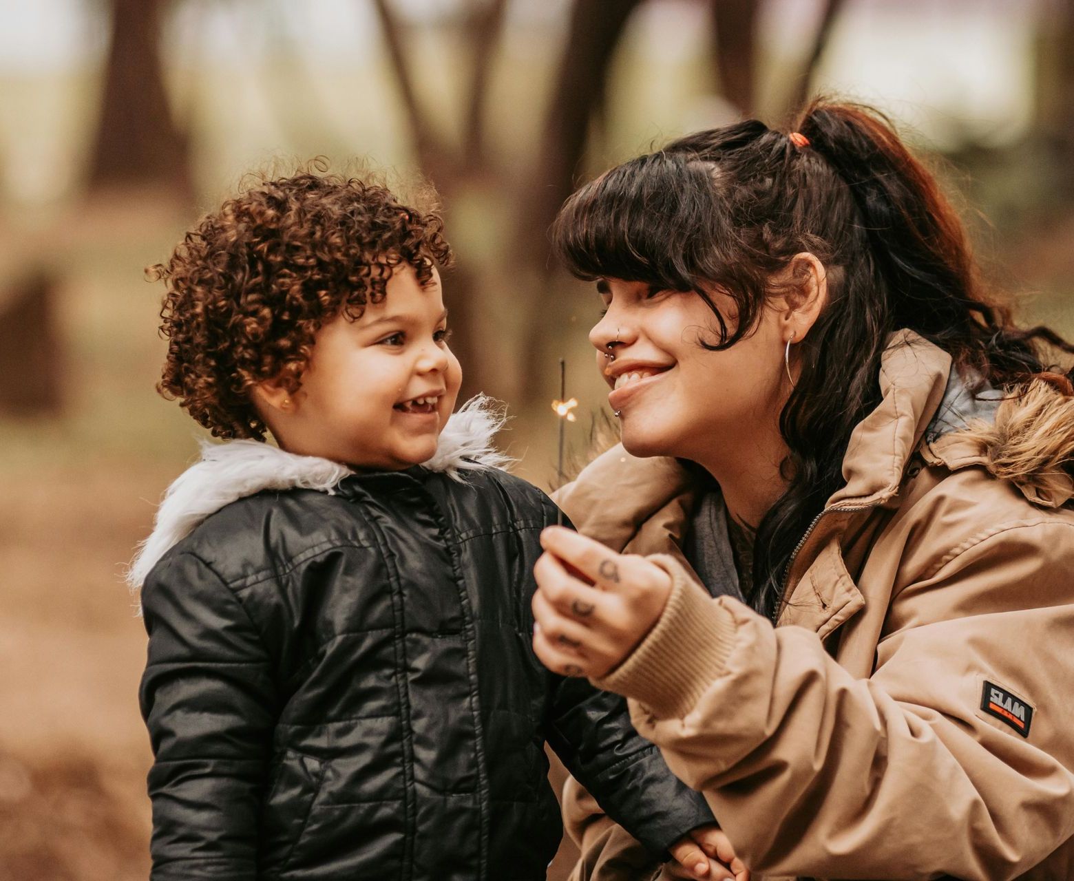 A young boy wearing glasses is laying on the floor reading a book.