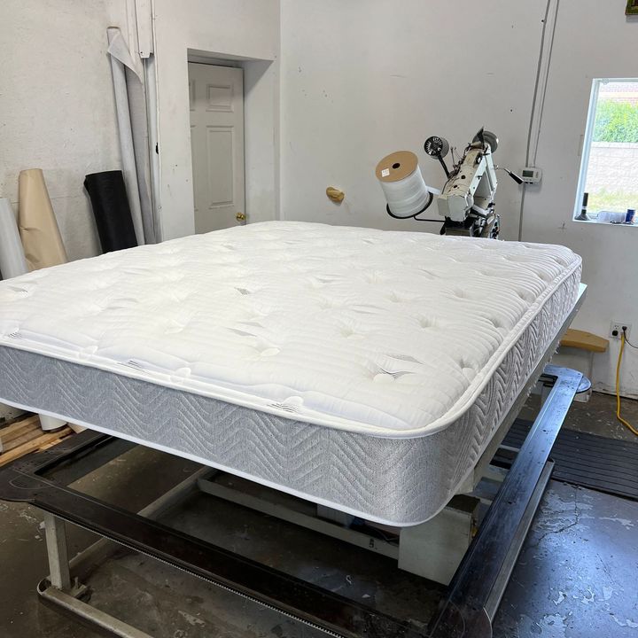 A white mattress is sitting on top of a table in a room.