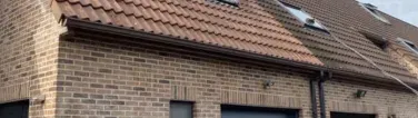 Renovatie van een gevel in Leuven, met vernieuwde bekleding en herstelling van metselwerk.