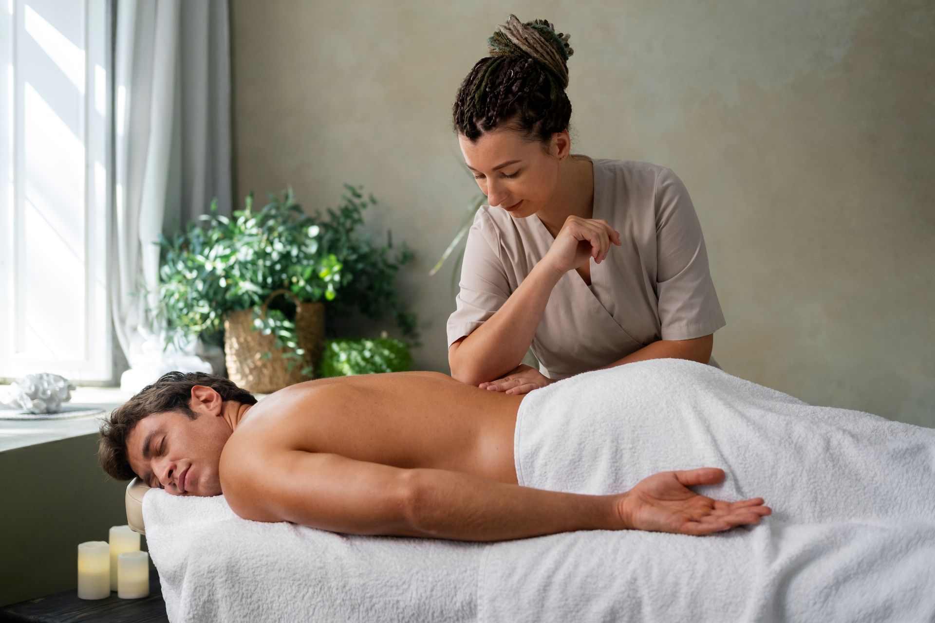 A man is laying on a massage table getting a massage from a woman.