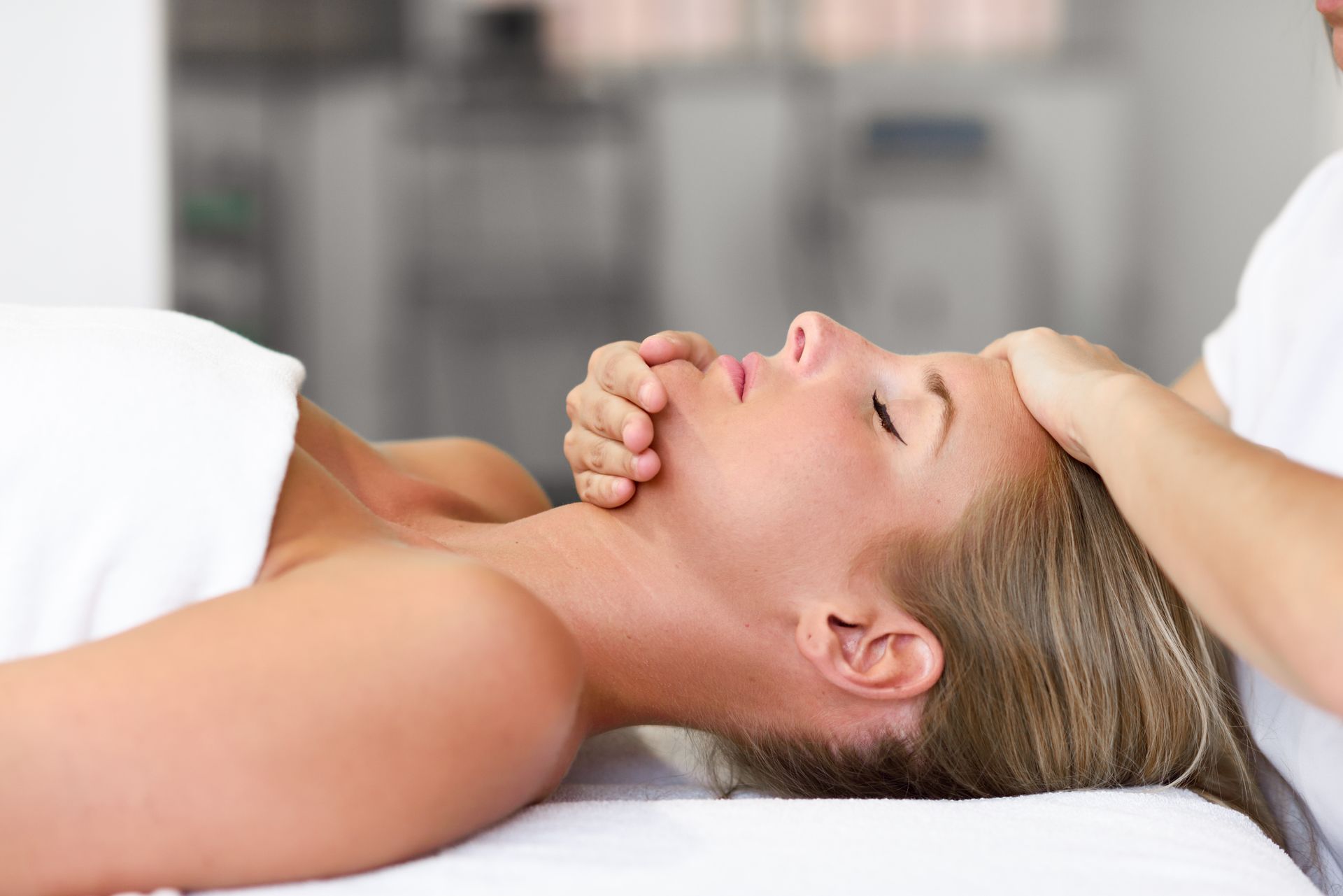 A woman is getting a head massage at a spa.