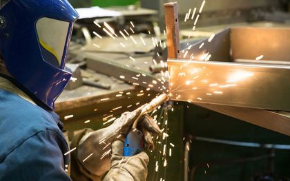 Person in protective clothing working on metal fabrication